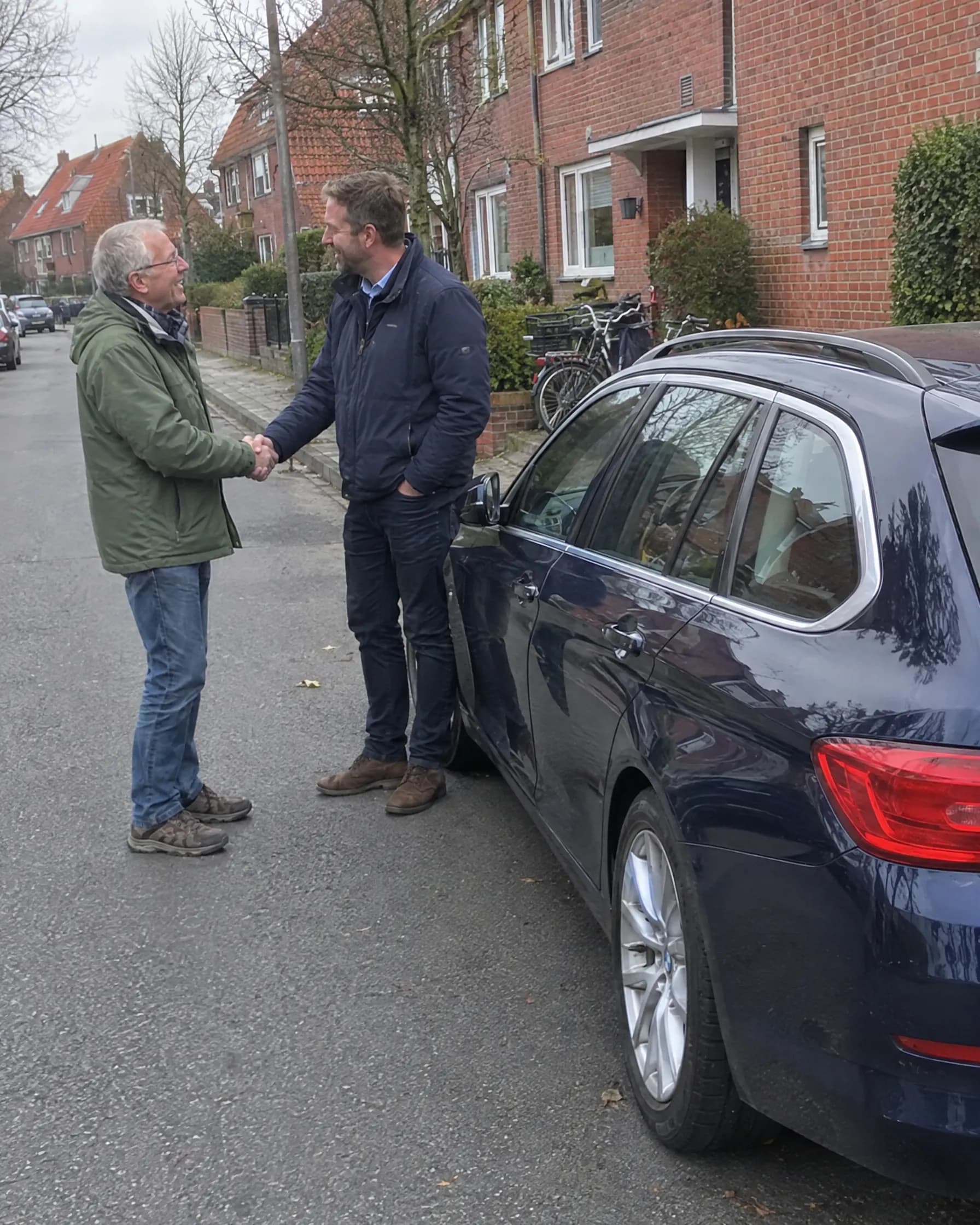 Verkäufer und Händler geben sich vor dem Auto die Hand