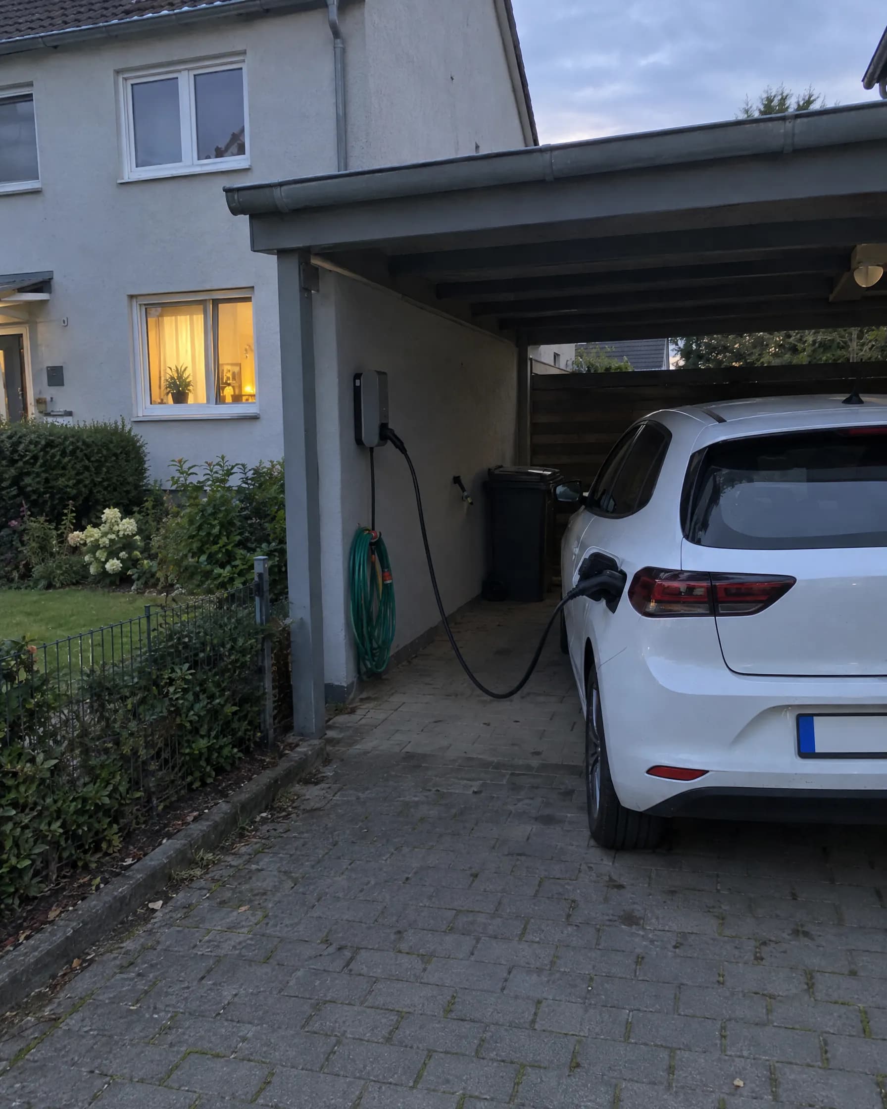 Elektroauto lädt an der Wallbox im Carport